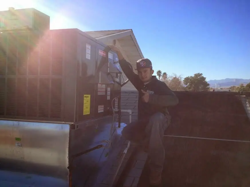 HVAC technician performing HVAC Inspection on a rooftop unit in Lone Grove